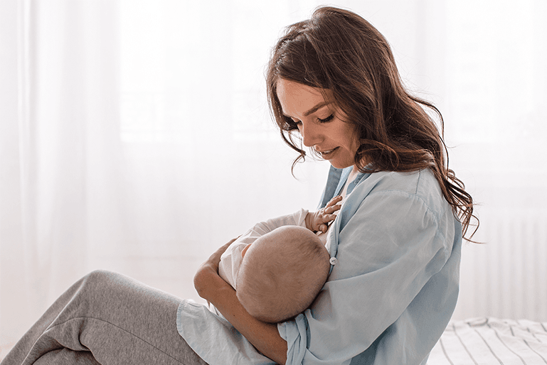 Mulher amamenta bebê com leite materno